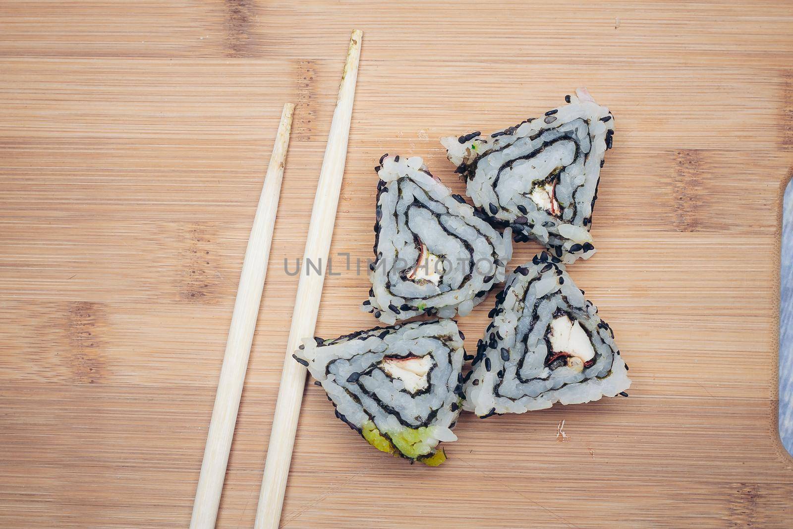 sushi rolls chopsticks wooden board top view. High quality photo