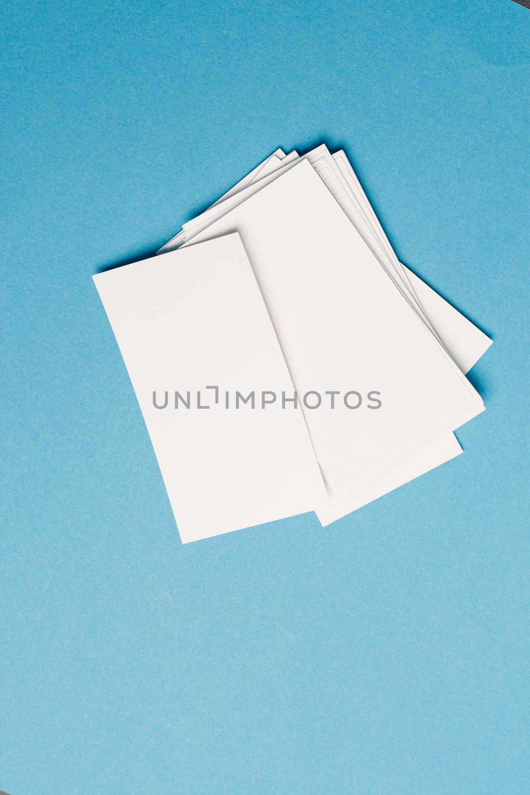 white business cards in the office on blue glass top view mockup. High quality photo