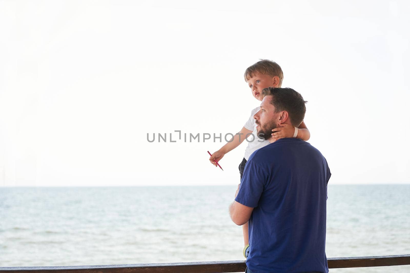 Father son together outside showing finger sea horizon back Man child spending time vacation enjoying summer Family with one child. Caucasian person beach