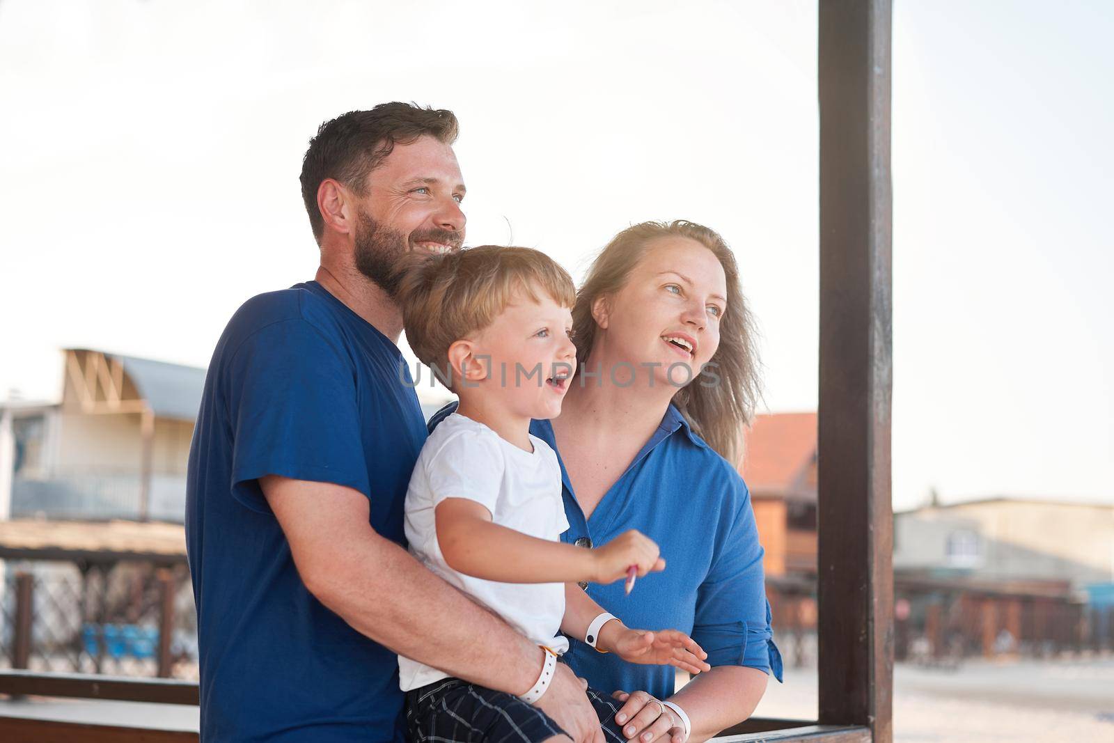 Mother father kid spending time together family vacation Parent dad mom walking with son enjoying sea beach Happy family concept. Blue color clothes. Family with one child
