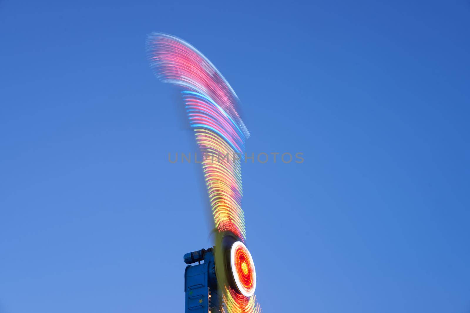 Amusement park blurred effect. Abstract illuminated background Spinning defocused carnival carousel long exposure shooting