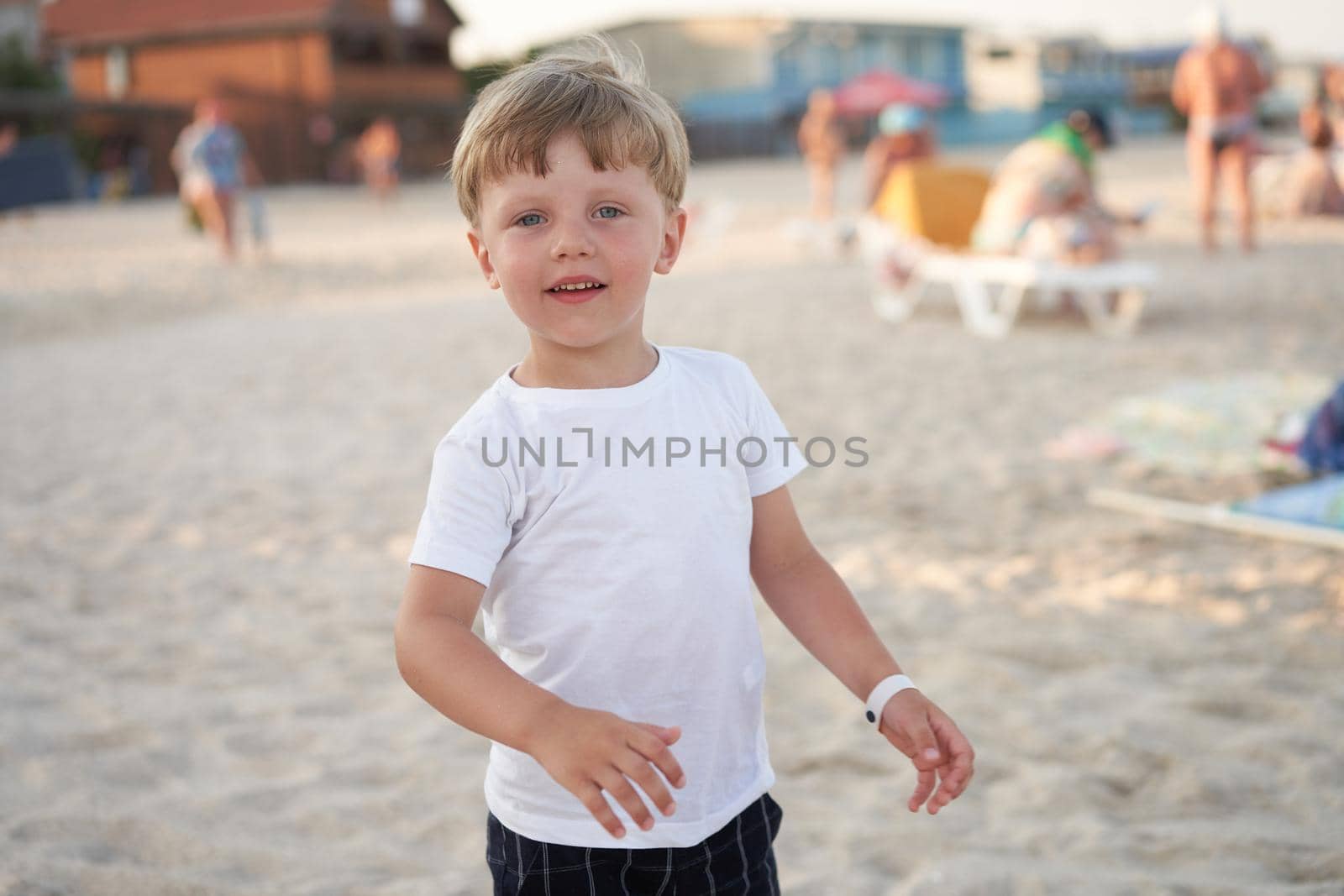 Caucasian boy standing beach. Childhood summertime. Family vacation with one child.