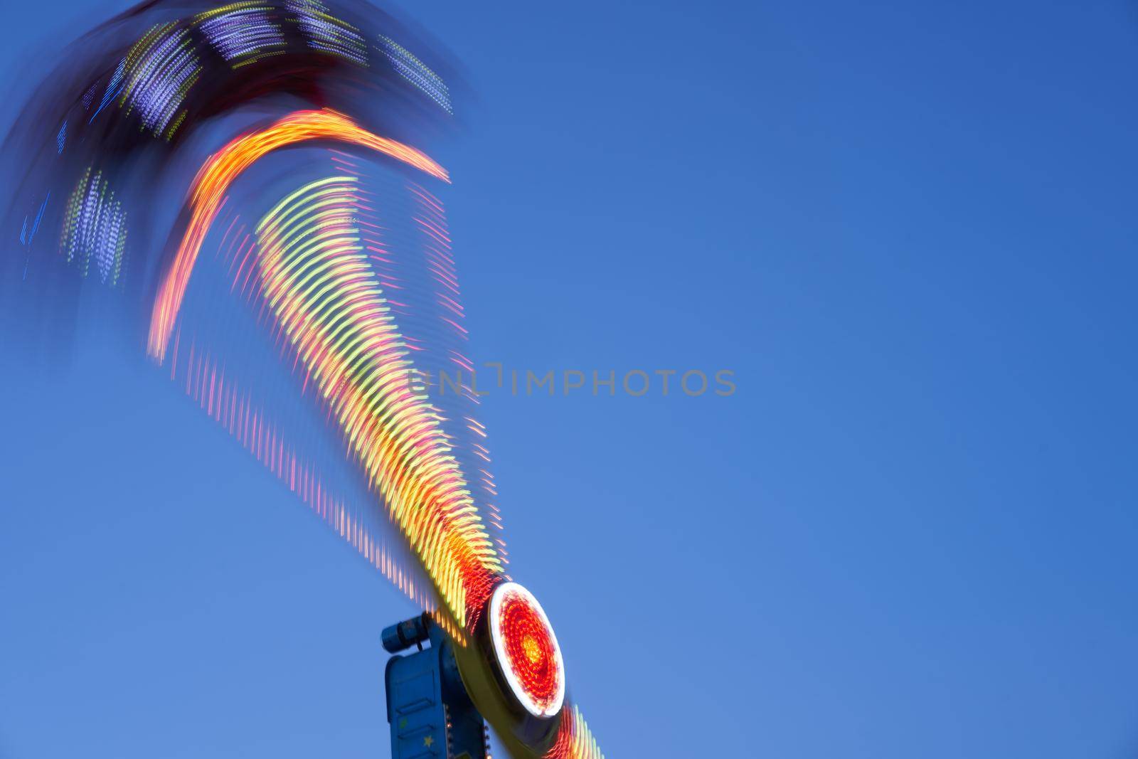 Amusement park blurred effect. Abstract illuminated background Spinning defocused carnival carousel long exposure shooting