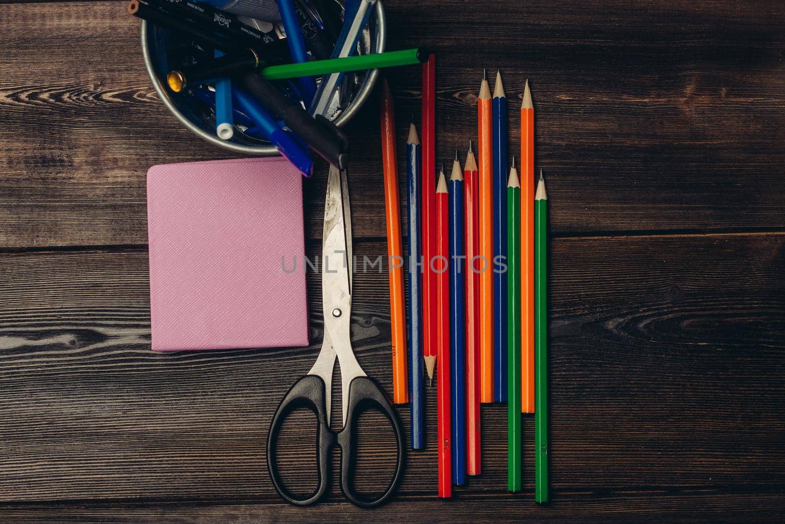 office scissors colored pencils notepad wooden table. High quality photo