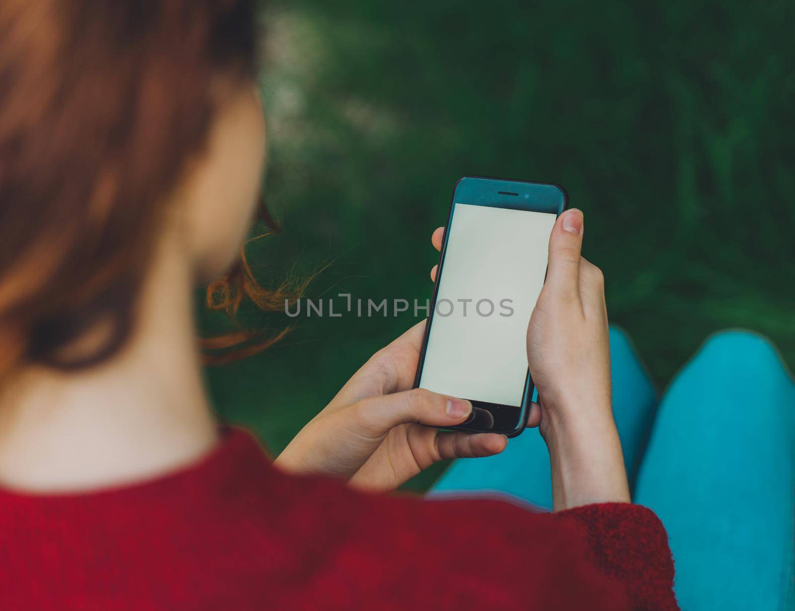 woman outdoors in the park with a phone in hand communication by SHOTPRIME