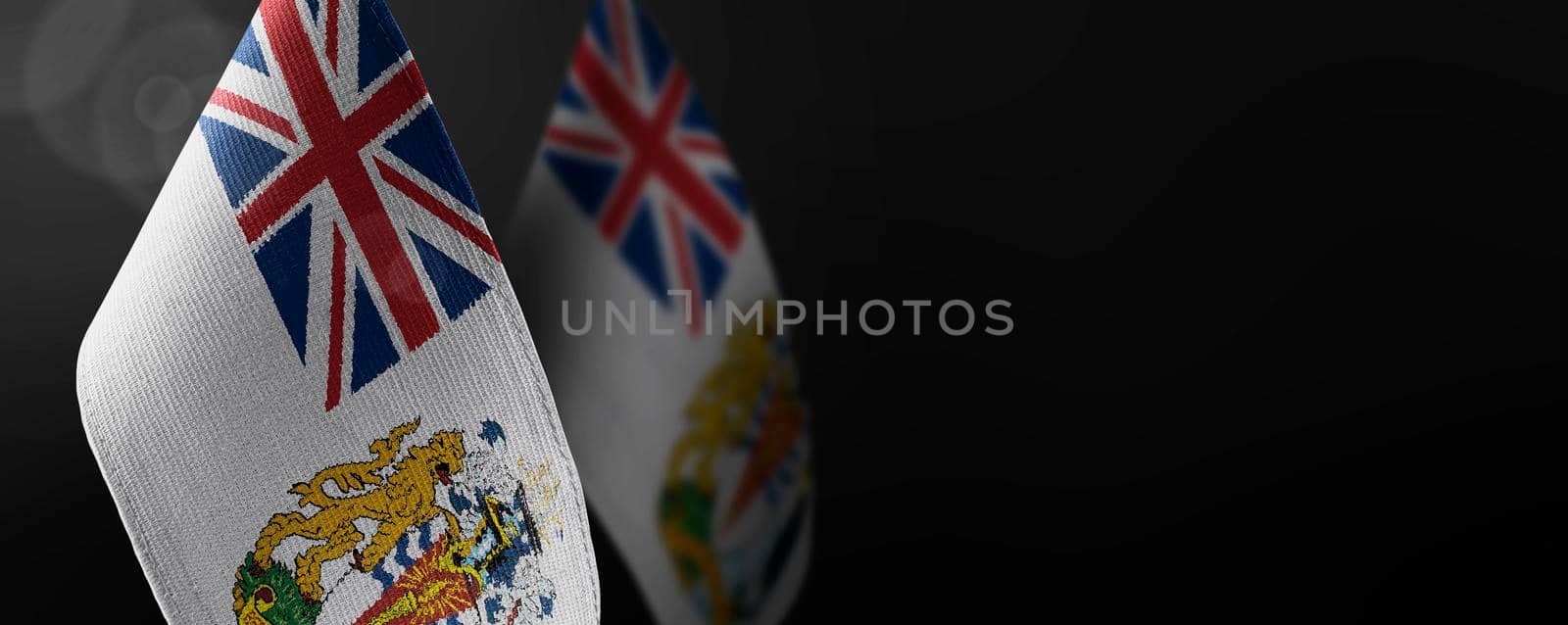 Small national flags of the British Antarctic Territory on a dark background.