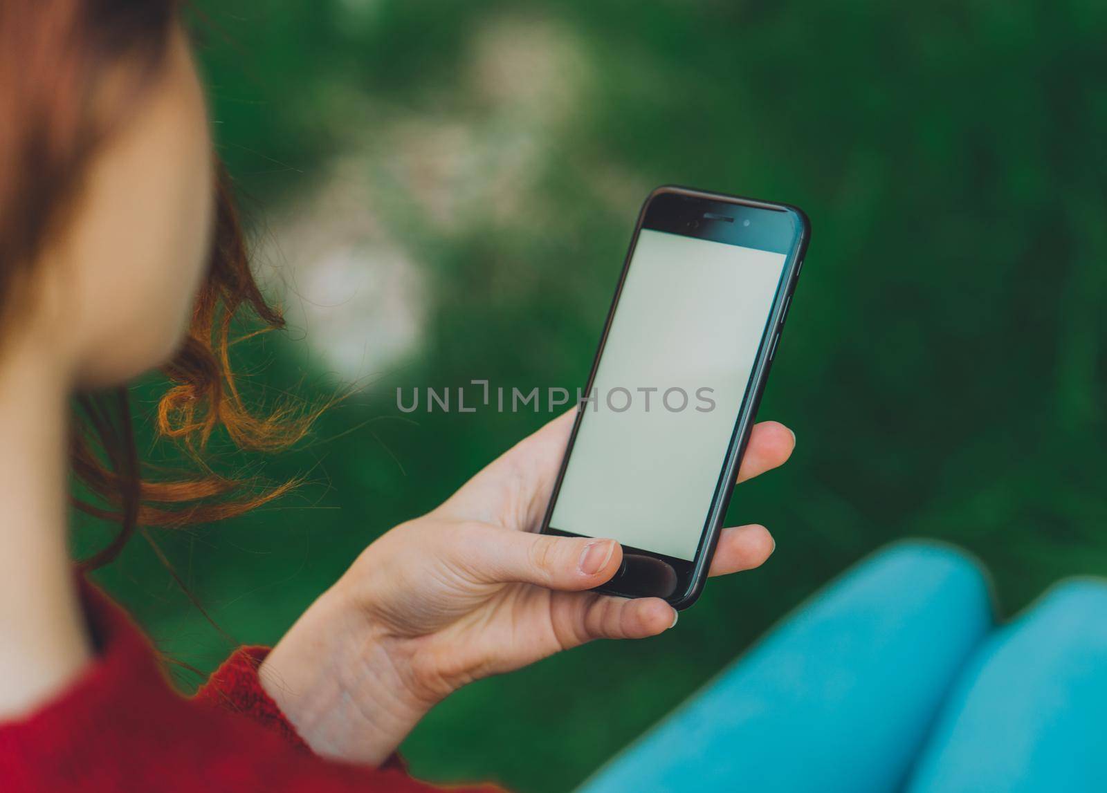 woman outdoors in the park with a phone in hand communication by SHOTPRIME