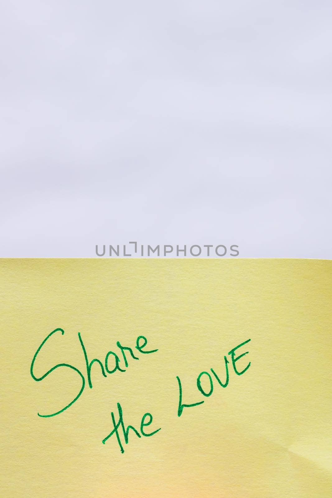 Share the love handwriting text close up isolated on yellow paper with copy space.
