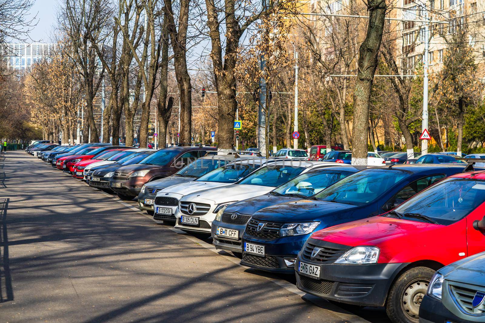 Parked cars along the street. Bucharest, Romania, 2021 by vladispas