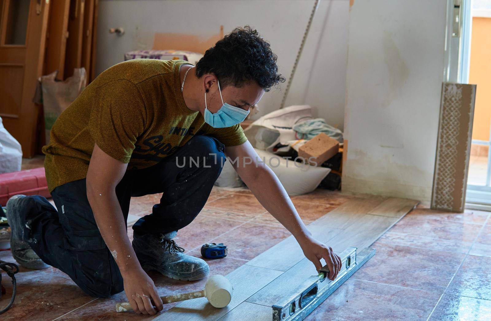 Bricklayer tiling a room by xavier_photo