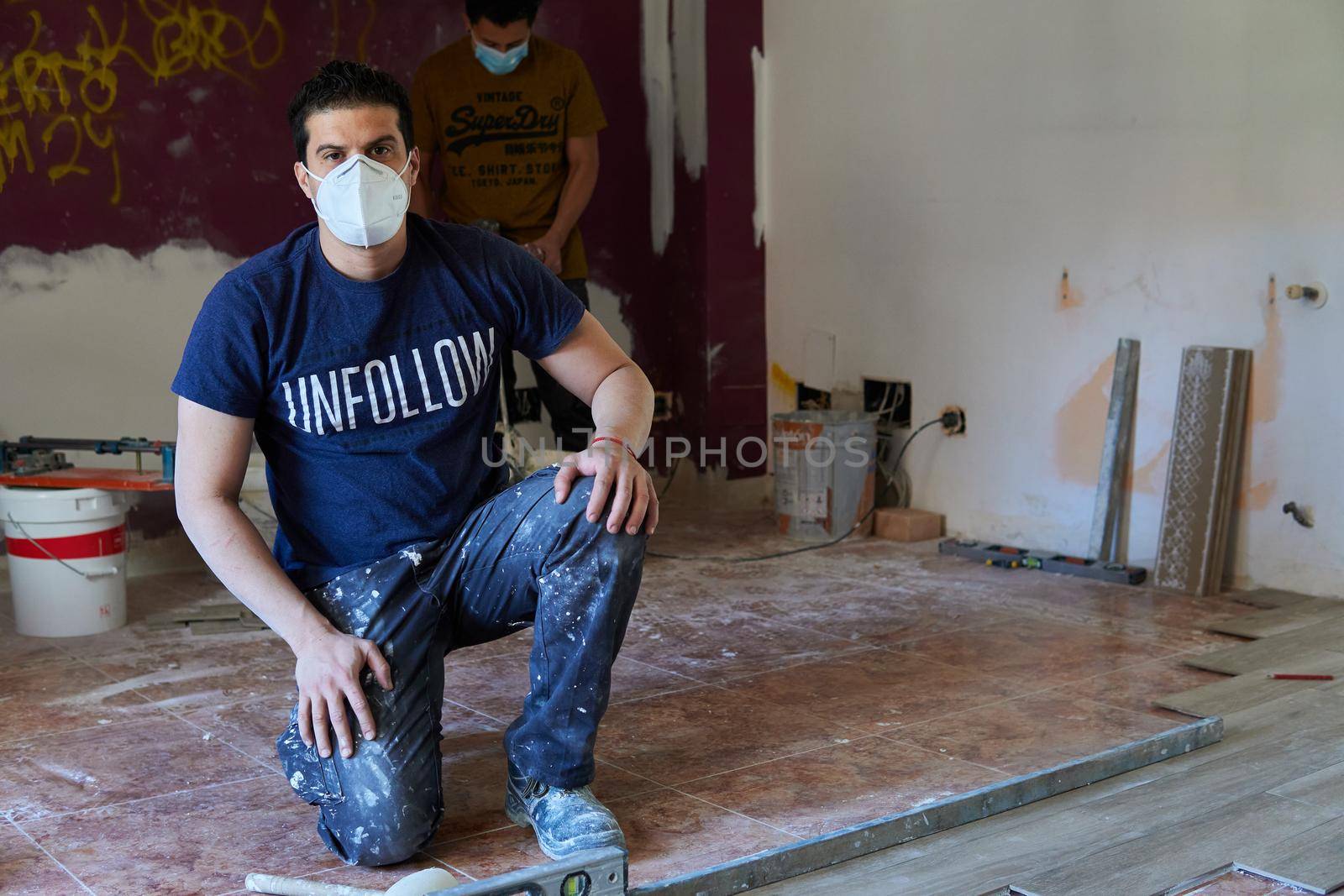 Bricklayer tiling a room by xavier_photo