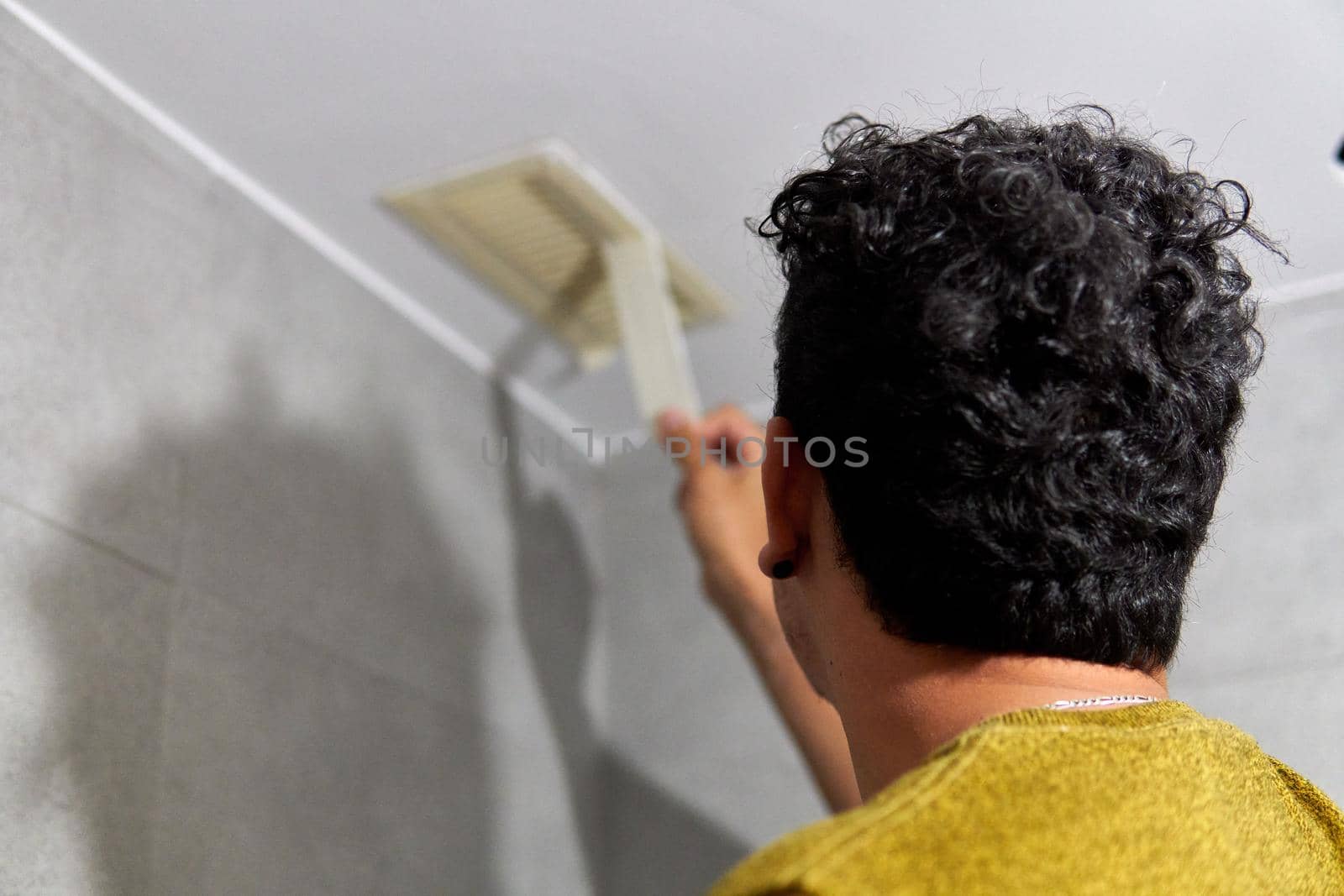 Painter preparing to paint a room with masking tape