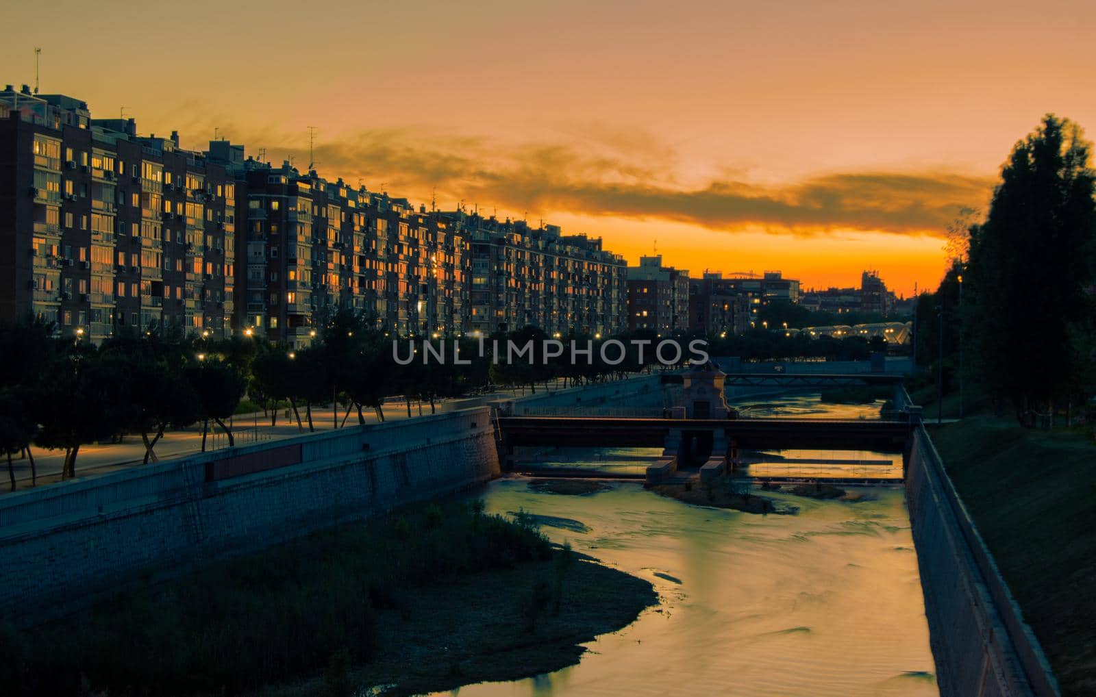 Madrid landscape on the river at sunset with buildings in the background