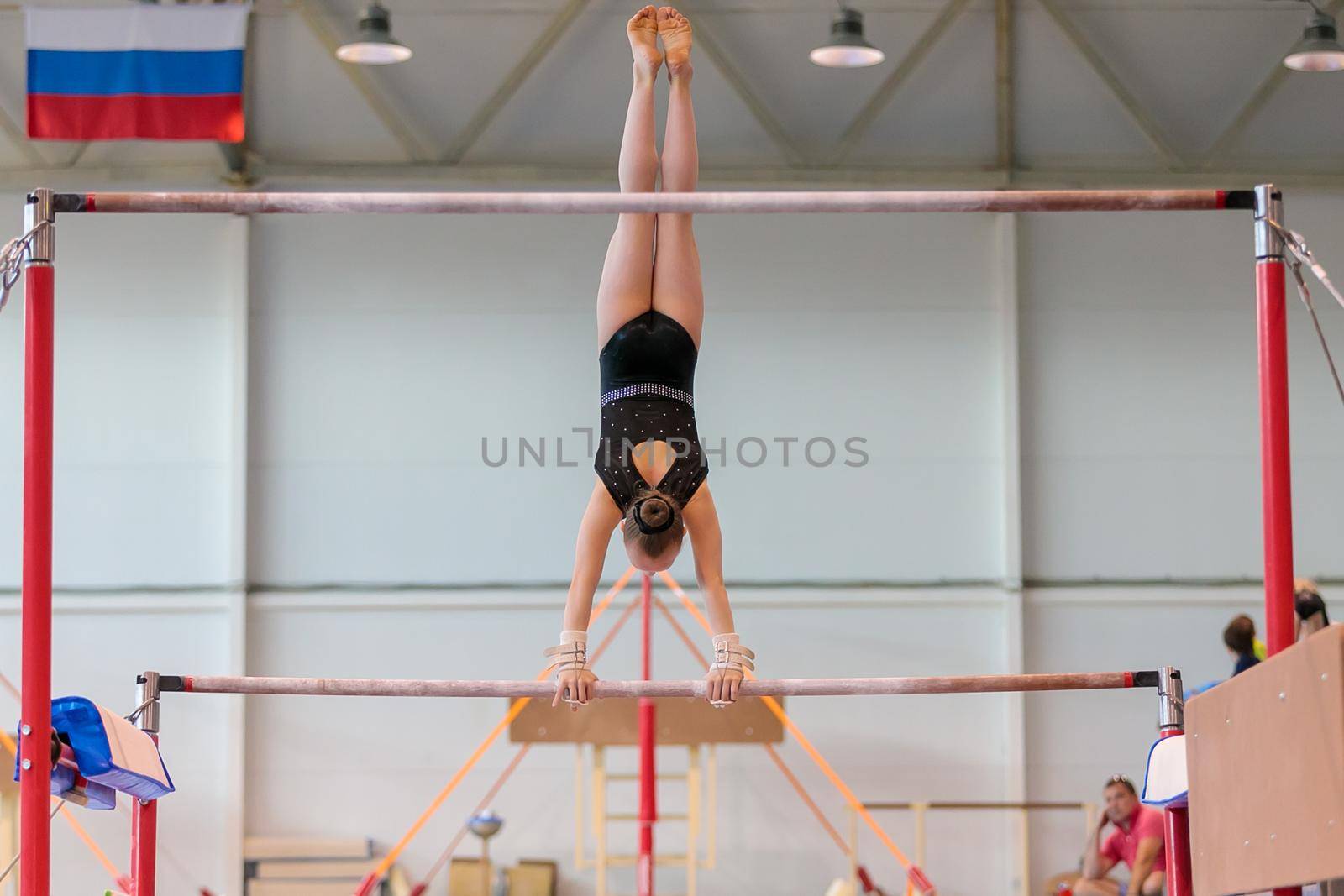 A girl in sportswear performs an exercise on the uneven bars. Rhythmic gymnastics, training in the hall. Moscow, Russia May 19, 2019