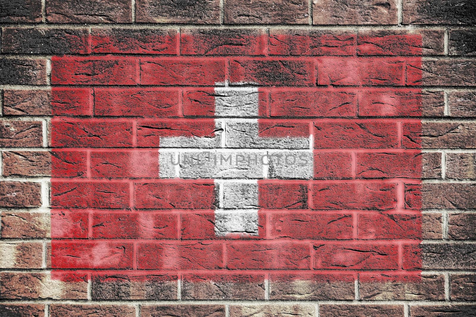 A Switzerland flag on a brick wall background
