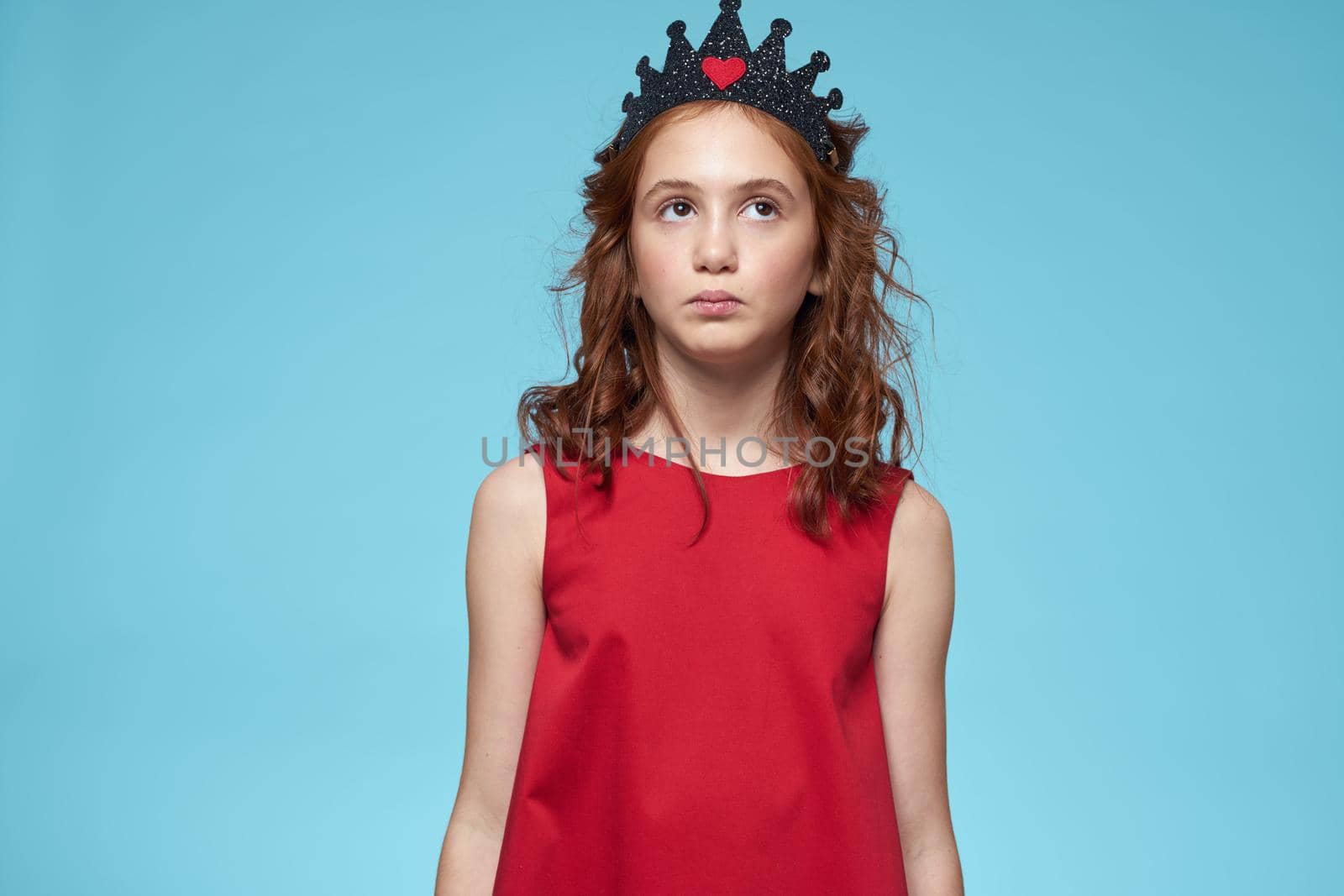 Girl in red dress with curly hair fun lifestyle blue background. High quality photo