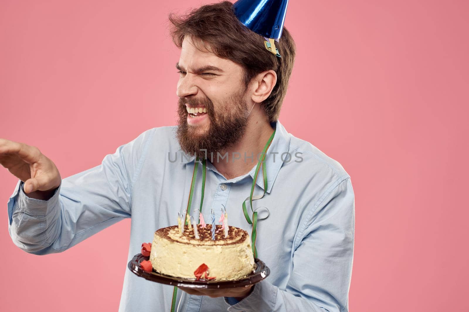 man with cake plate on pink background and in shirt cropped view. High quality photo