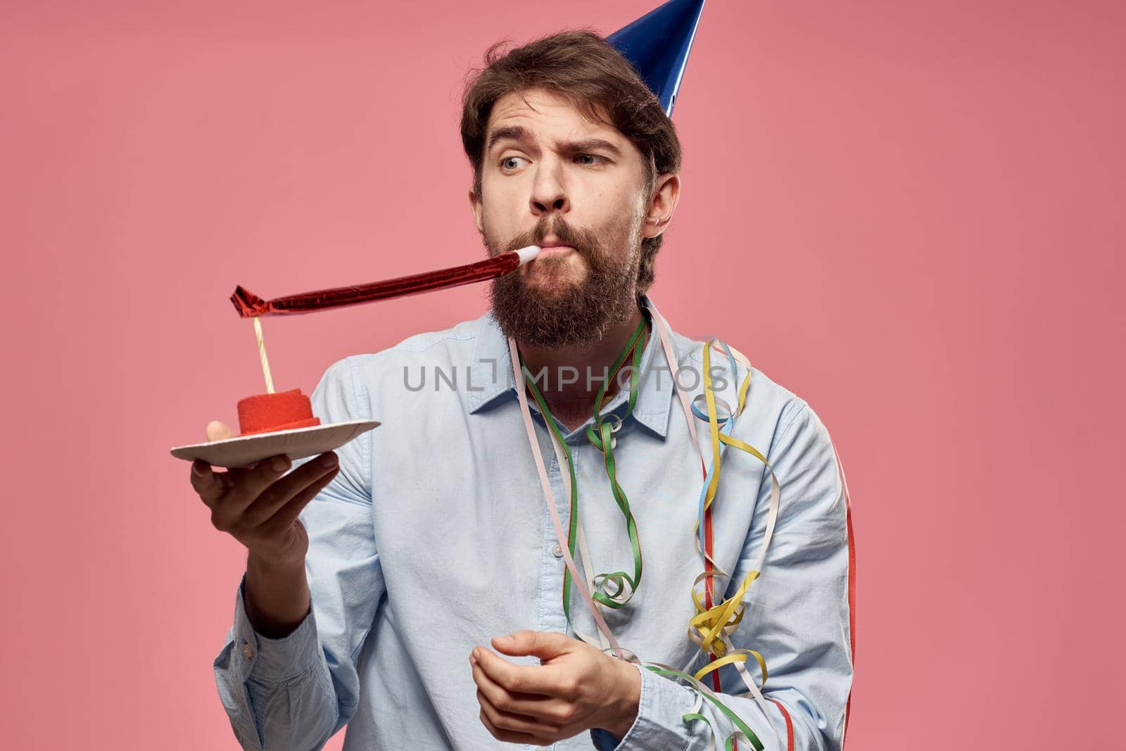 bearded man with cake on pink background emotions cropped view. High quality photo