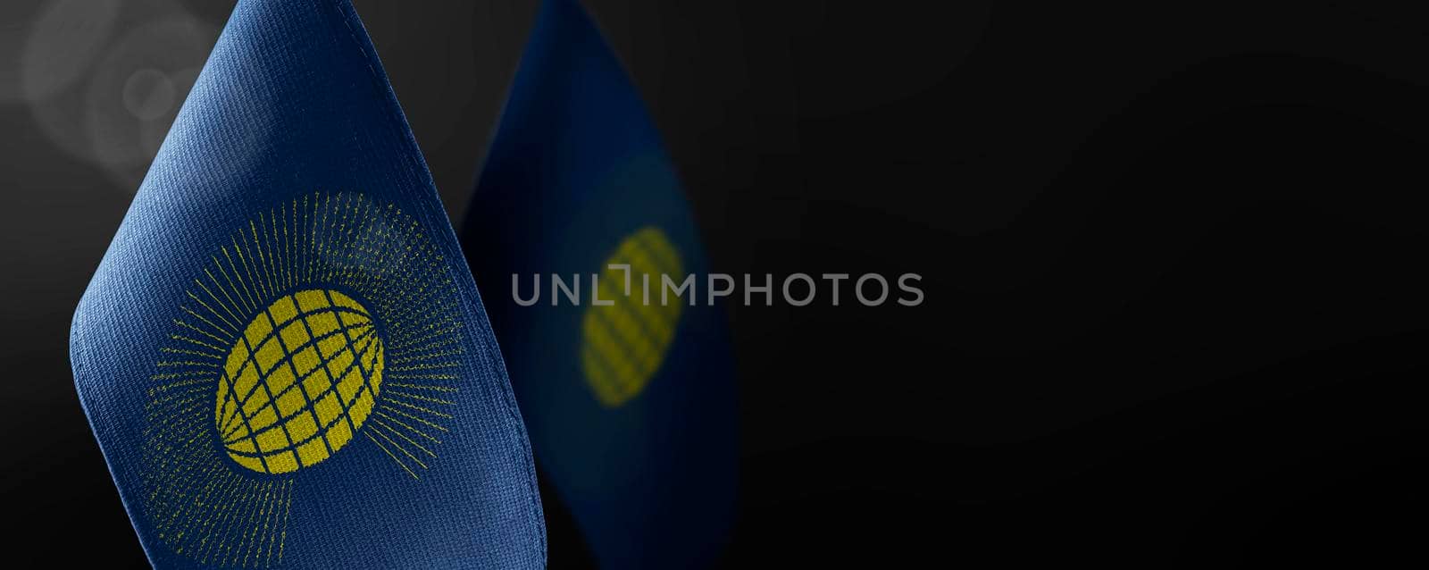 Small national flags of the Commonwealth on a dark background.