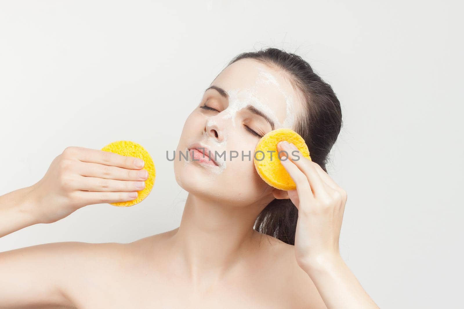 woman with bare shoulders wipes the mask with sponges. High quality photo