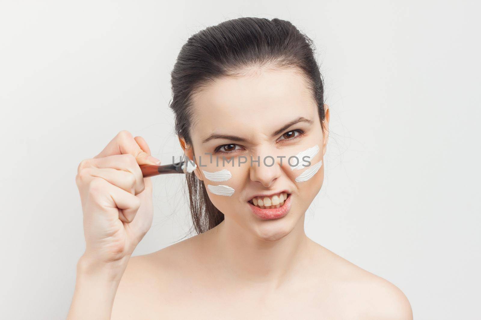 brunette naked shoulders face mask brush in hands skin care procedures. High quality photo