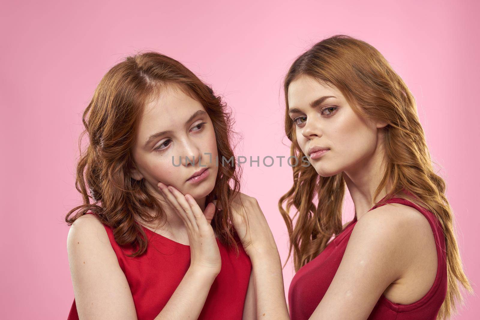Mom and daughter fun communication family joy pink background cropped view. High quality photo
