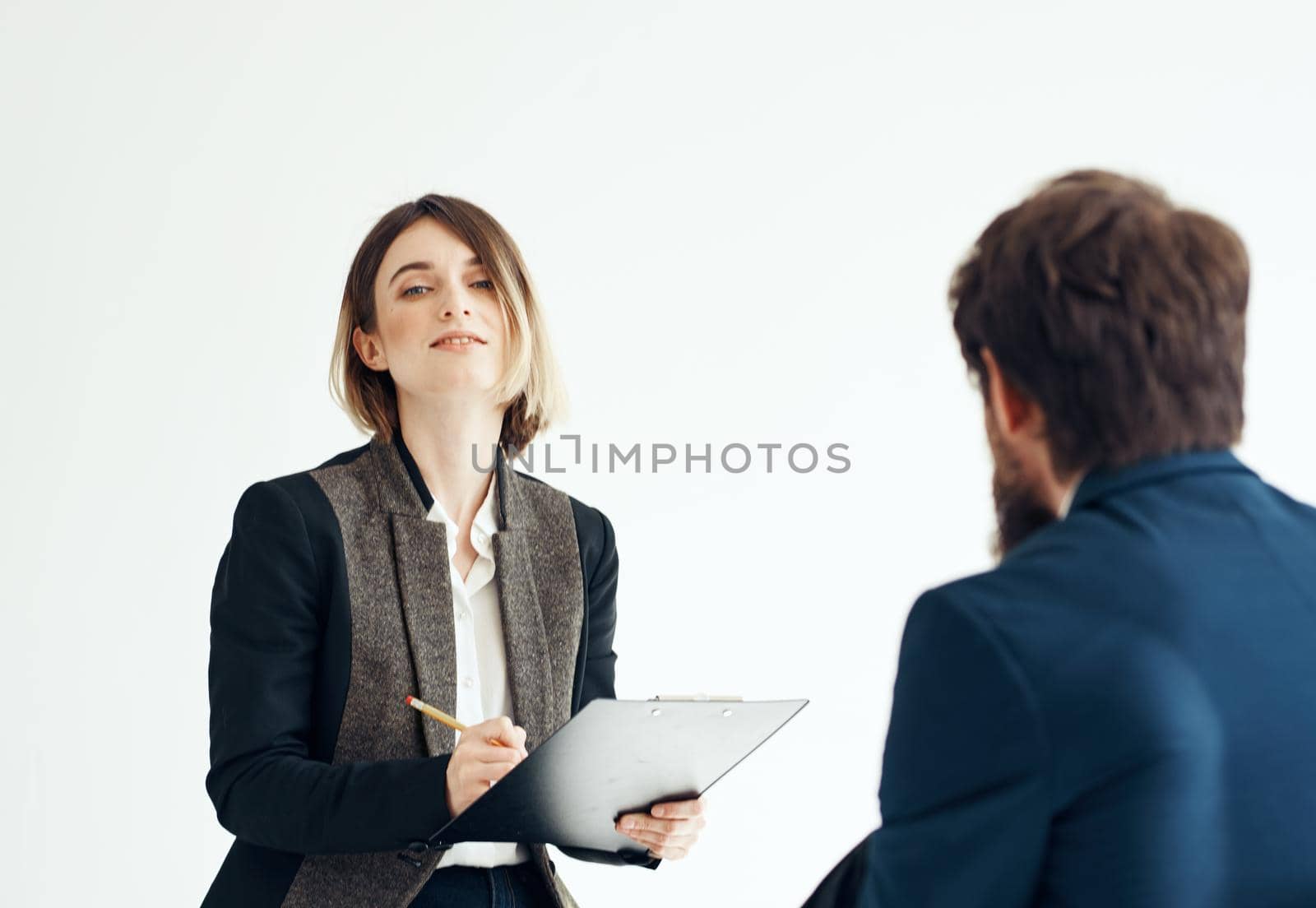 A man for an interview In a bright room talking to a woman opposite. High quality photo