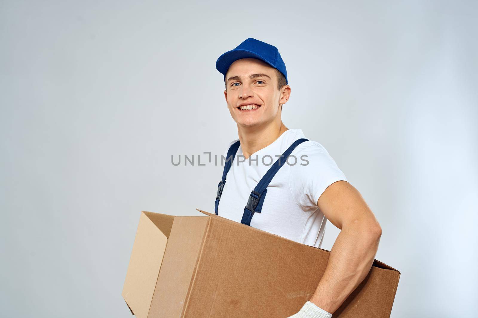 A man in a working uniform loading cardboard boxes providing services. High quality photo