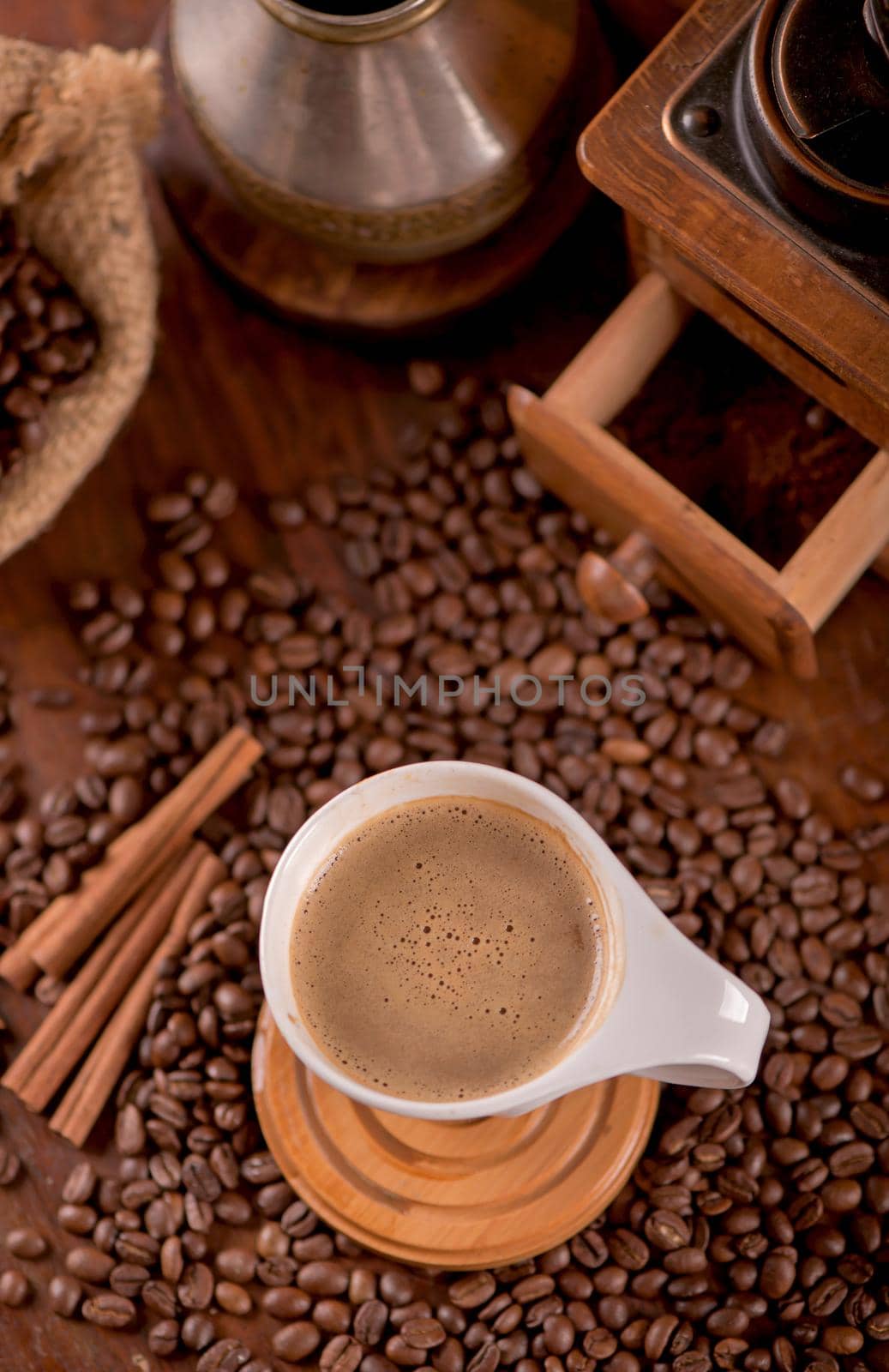 cup of coffee and coffee beans in a sack on dark background, top view by aprilphoto