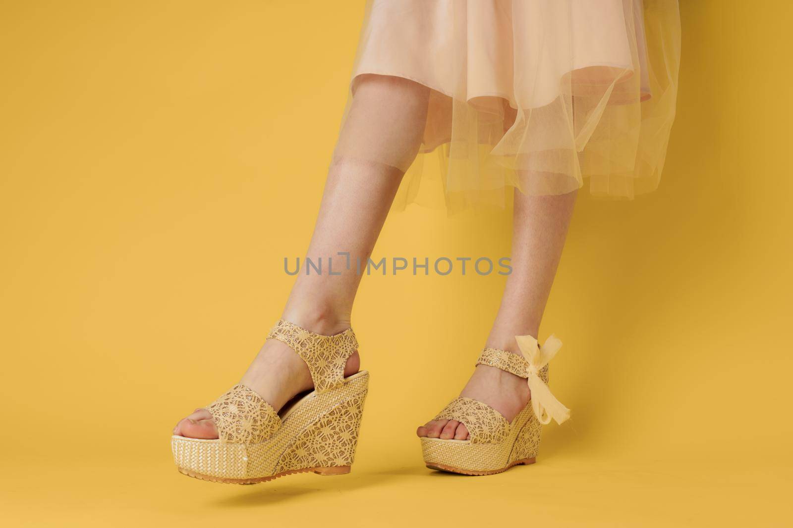 Female feet fashionable shoes attractive look yellow background lifestyle by SHOTPRIME