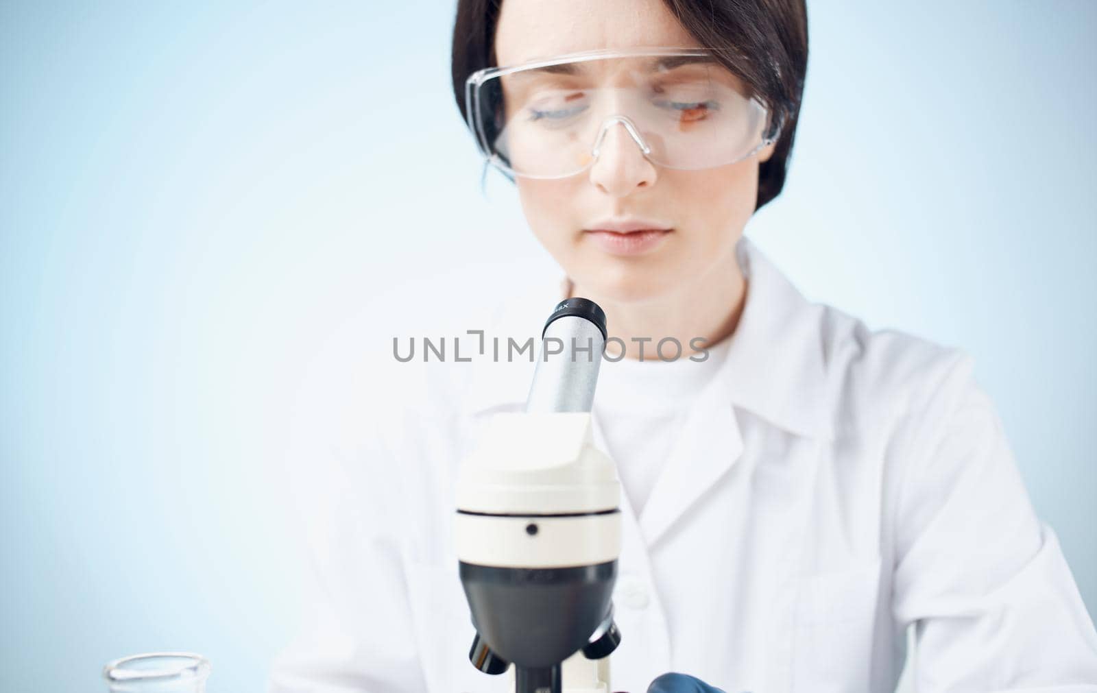 doctors in medical gloves look through a microscope on the table e laboratory chemical element vaccine. High quality photo