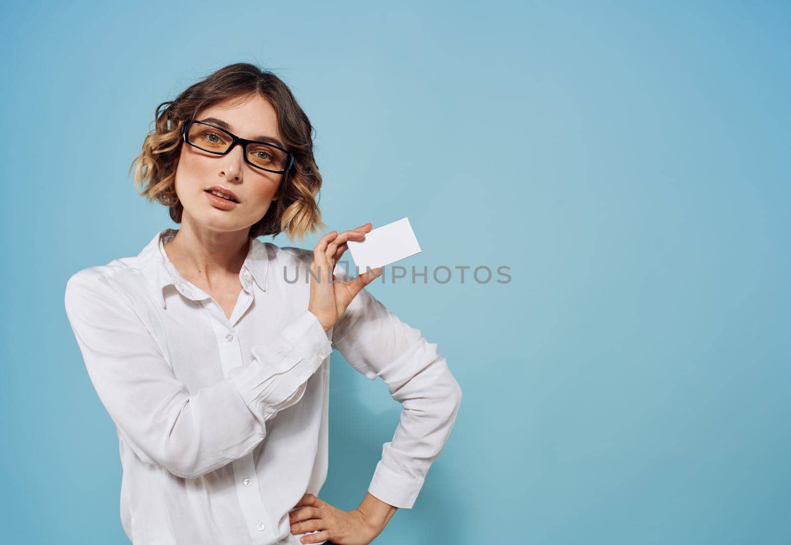 woman with white letterhead in hands shirt glasses hairstyle blue background. High quality photo