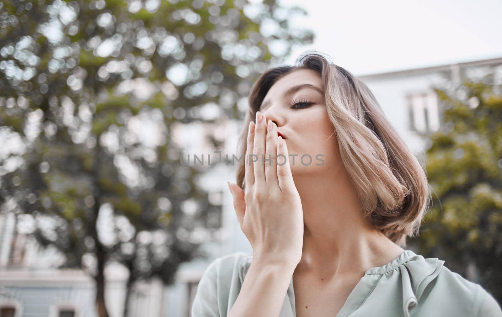 beautiful blonde with red lips outdoors near the building gestures with her hands emotions Copy Space. High quality photo