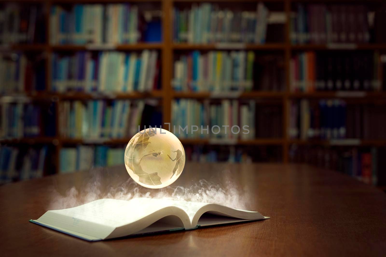 An open book glows brightly and reveals a globe of the world, in old self of book library university background among. by thanumporn
