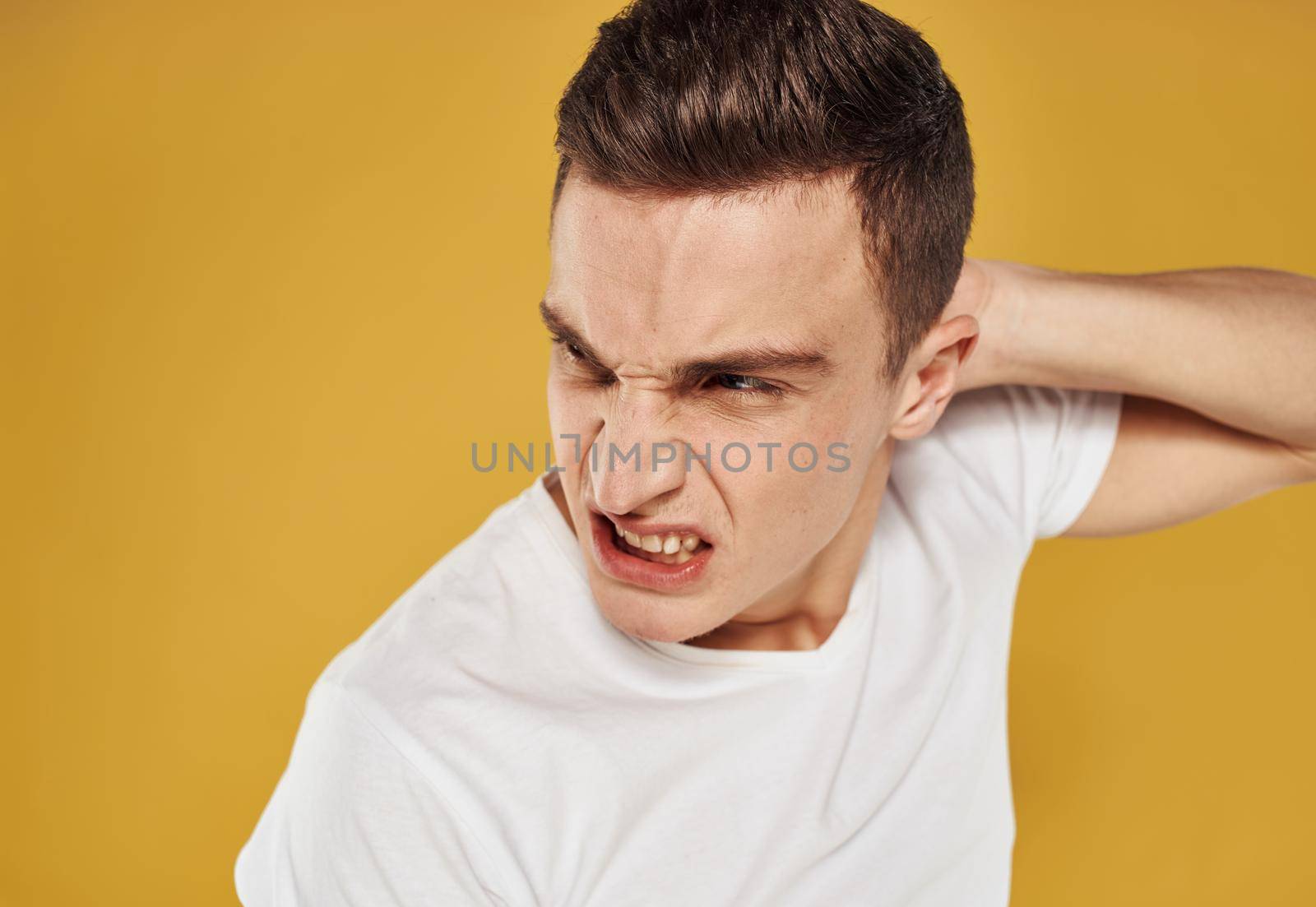 Aggressive man touches his head emotions model irritability. High quality photo