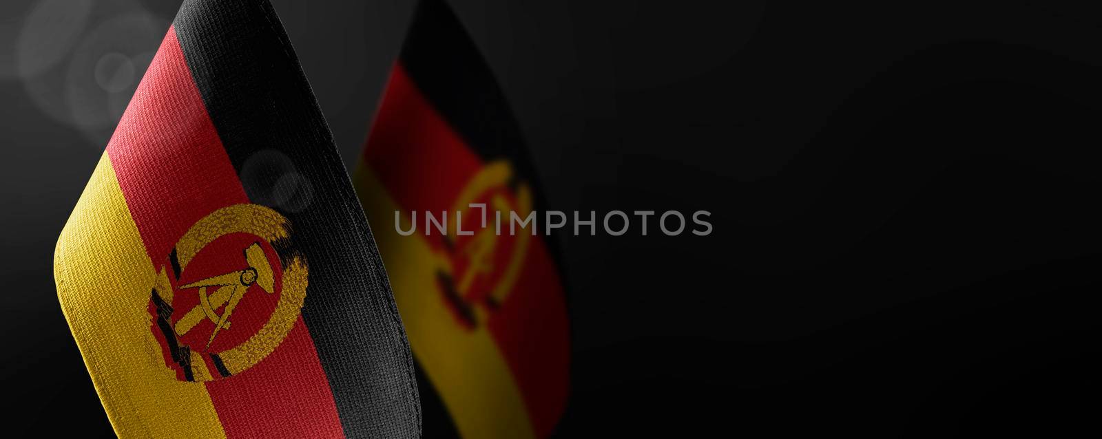 Small national flags of the GDR on a dark background.