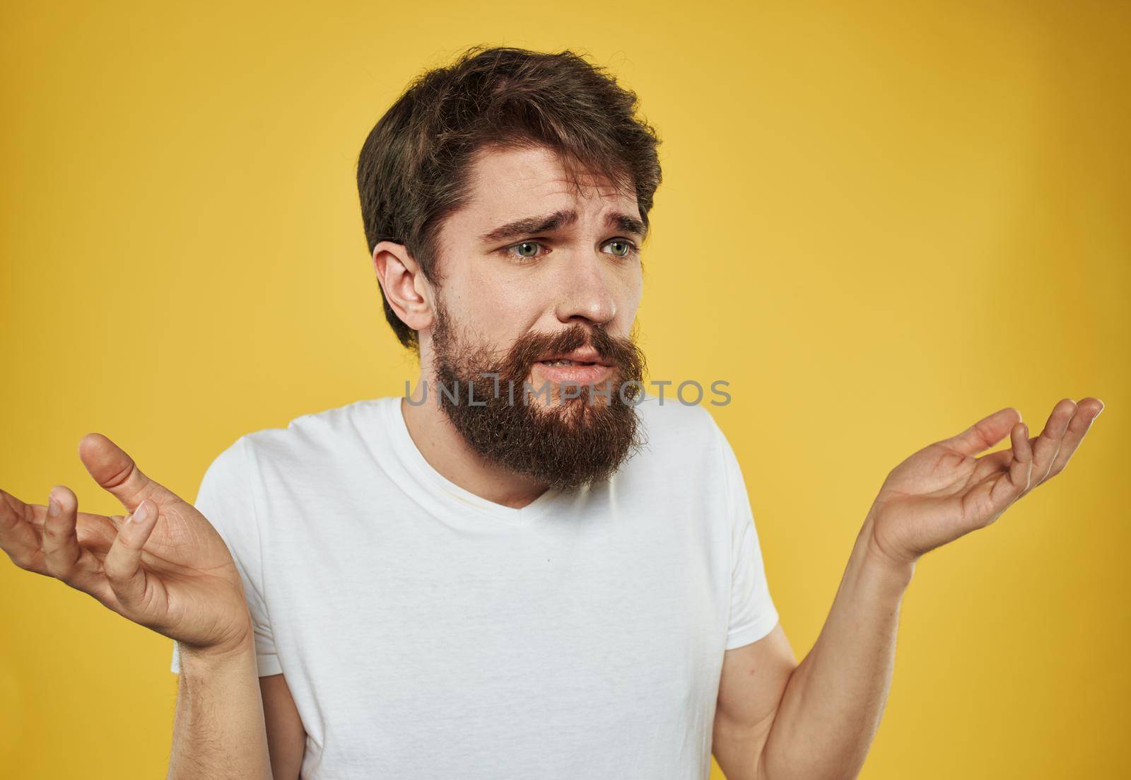 The man has his arms crossed over his chest against a yellow background cropped view. High quality photo