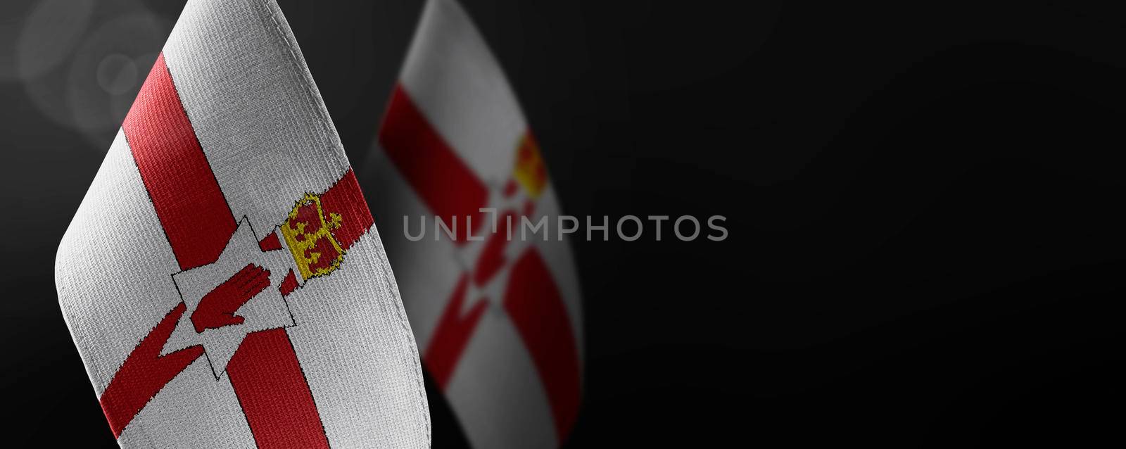 Small national flags of the Northern Ireland on a dark background.