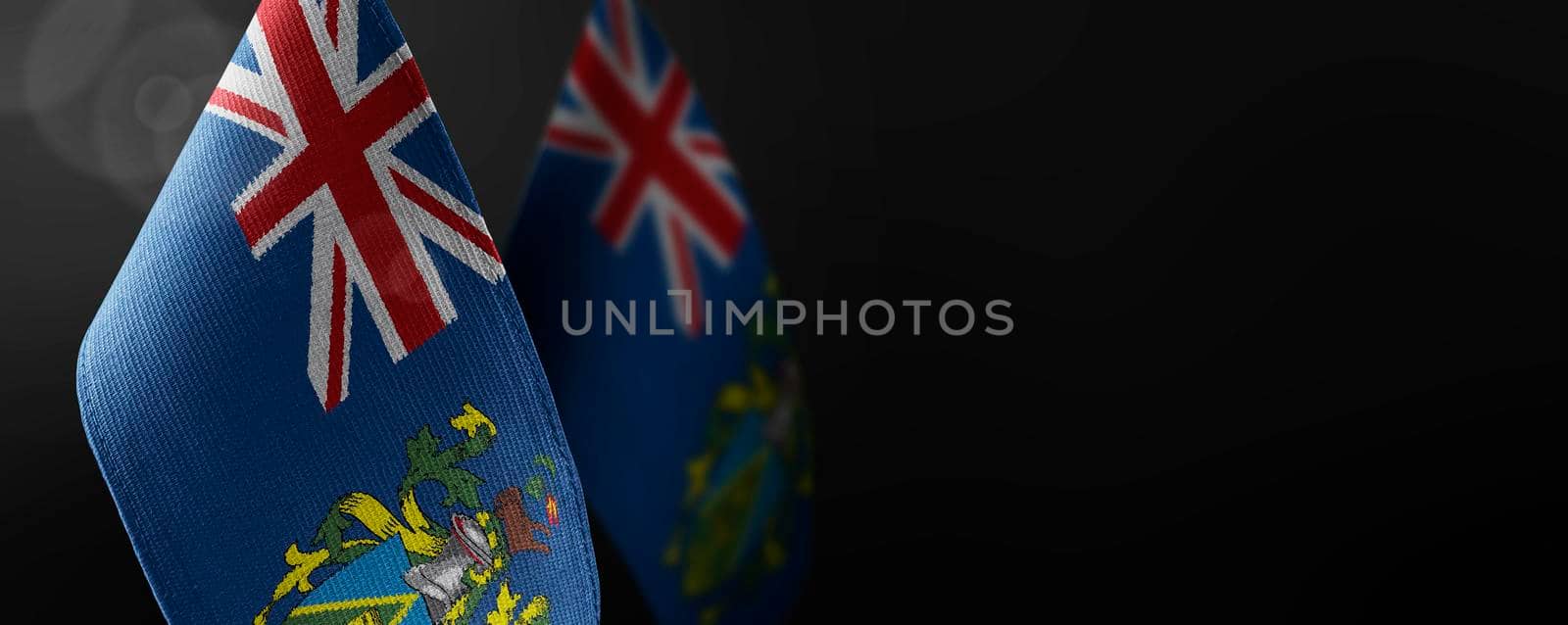 Small national flags of the Pitcairn Islands on a dark background.