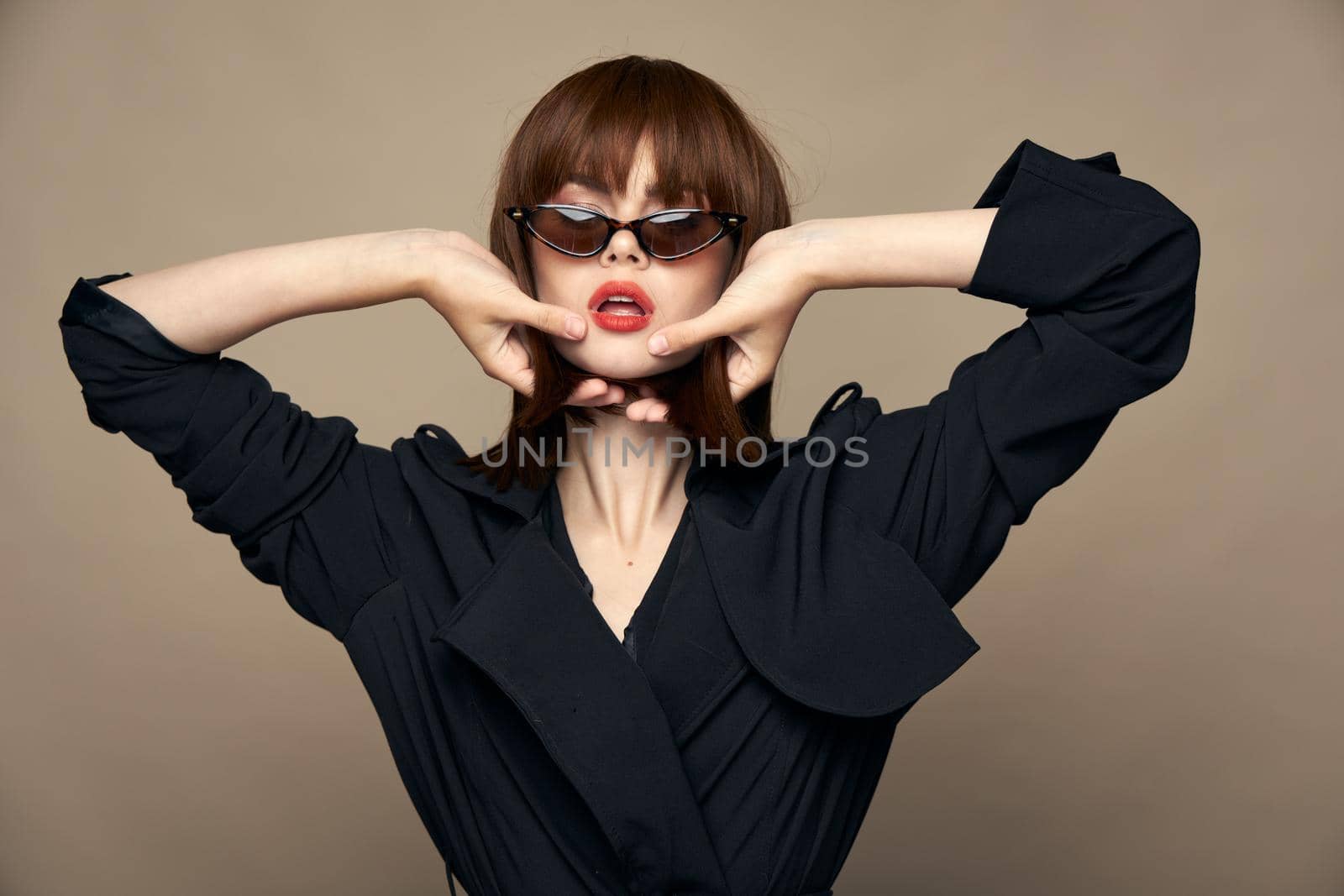 Charming brunette Party model holds hands near face and glasses red lips cropped view
