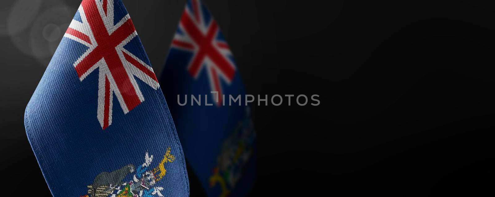 Small national flags of the South Georgia and the South Sandwich Islands on a dark background by butenkow