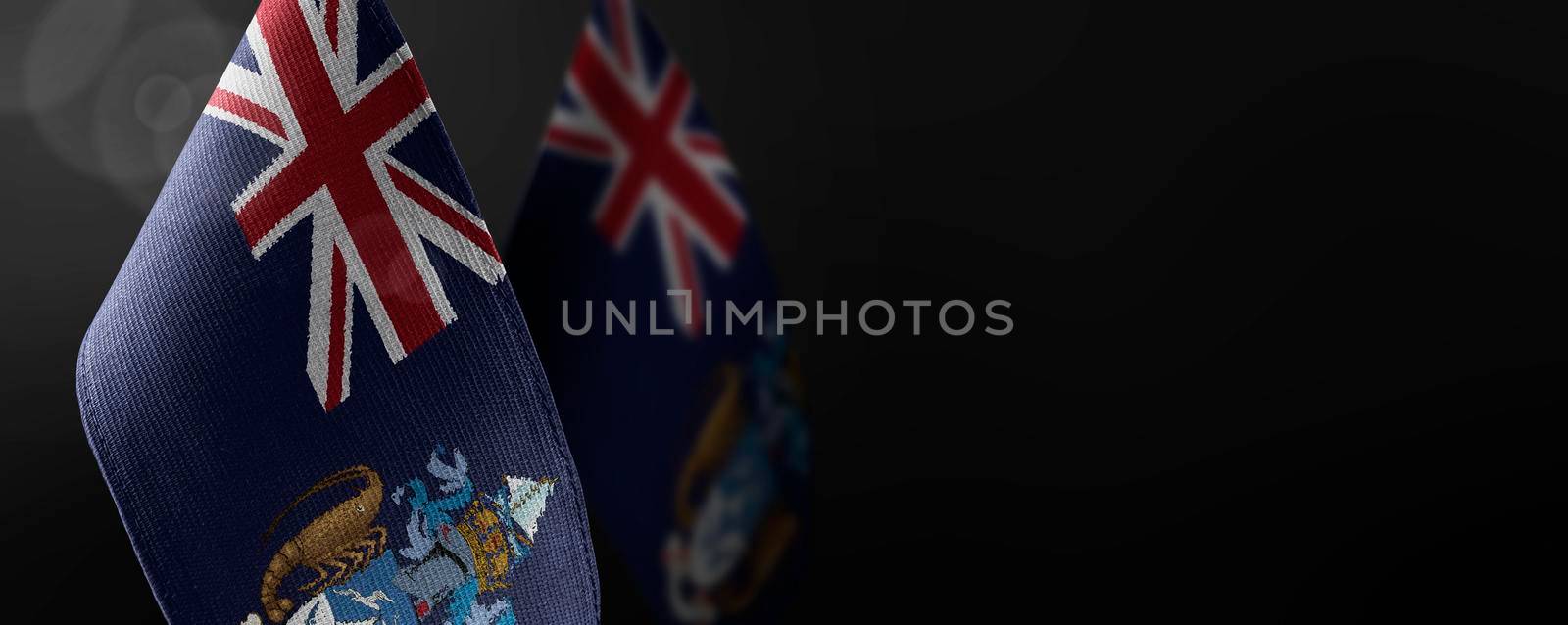 Small national flags of the Tristan da Cunha on a dark background by butenkow