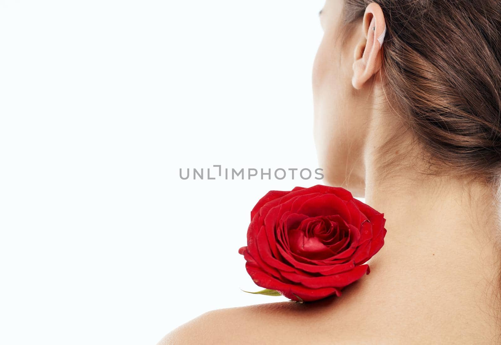 Romantic woman with red fragrant flower near the face clean skin cosmetology dermatology. High quality photo
