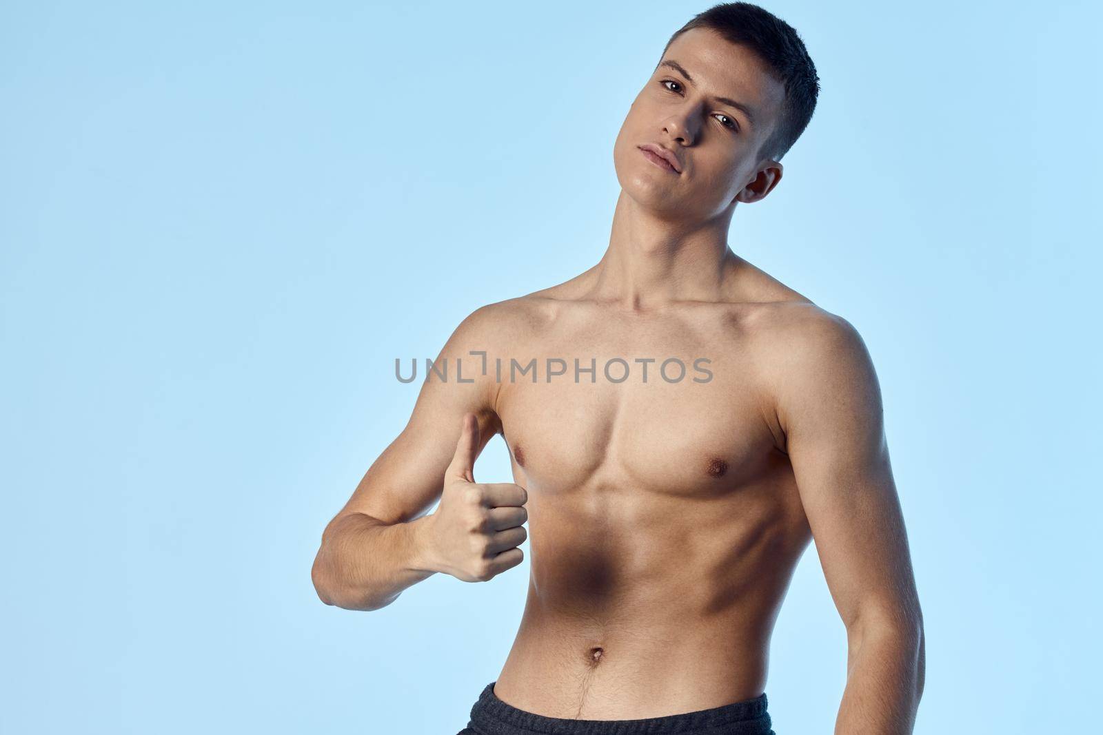 sporty man showing thumb on blue background cropped view. High quality photo