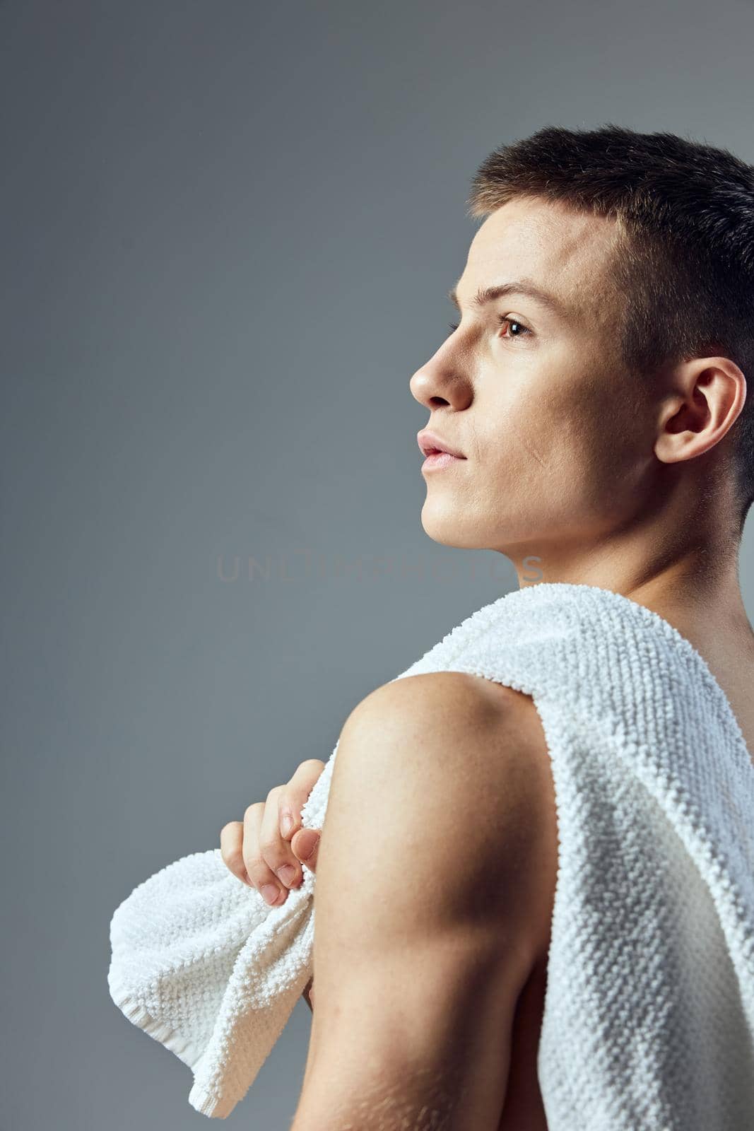 portrait of sporty man with towel on shoulders side view cropped view isolated workout background. High quality photo