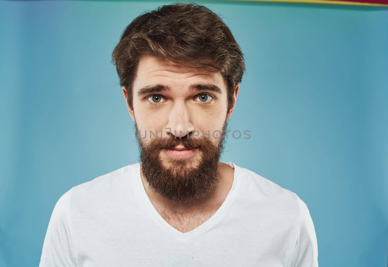 Portrait of a man with a thick beard white t-shirt brunette model close-up. High quality photo