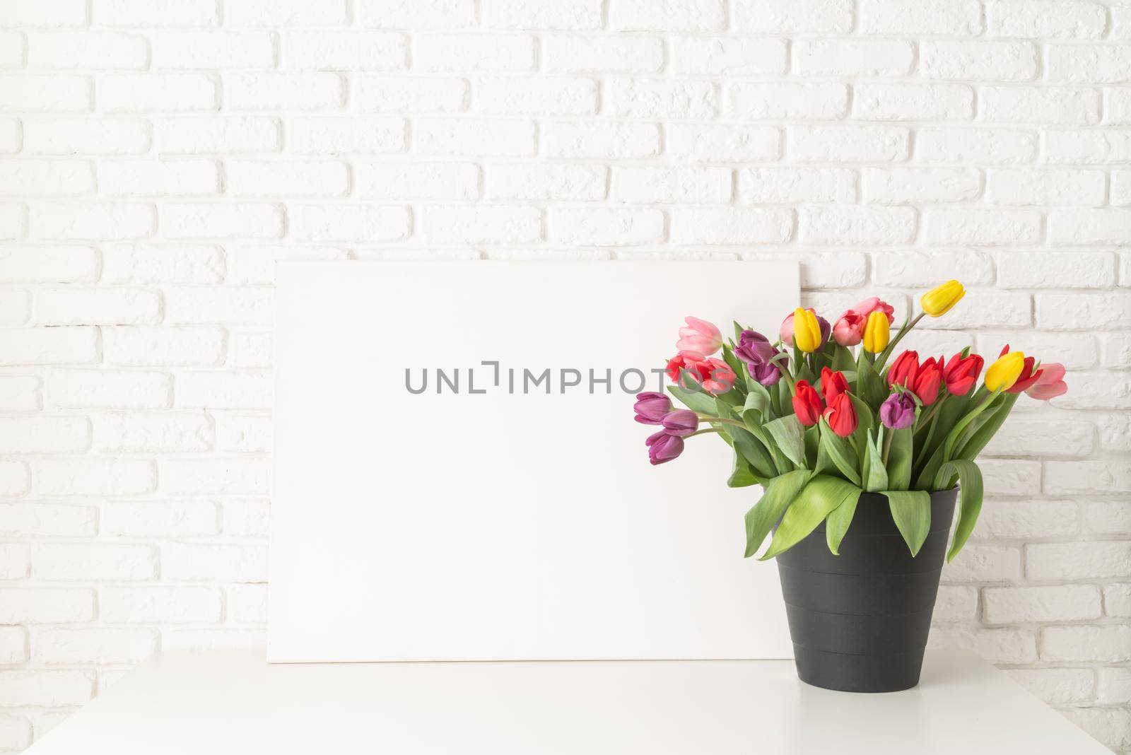 Mock up design. Mock up with Frame and bucket of tulips on white brick wall background