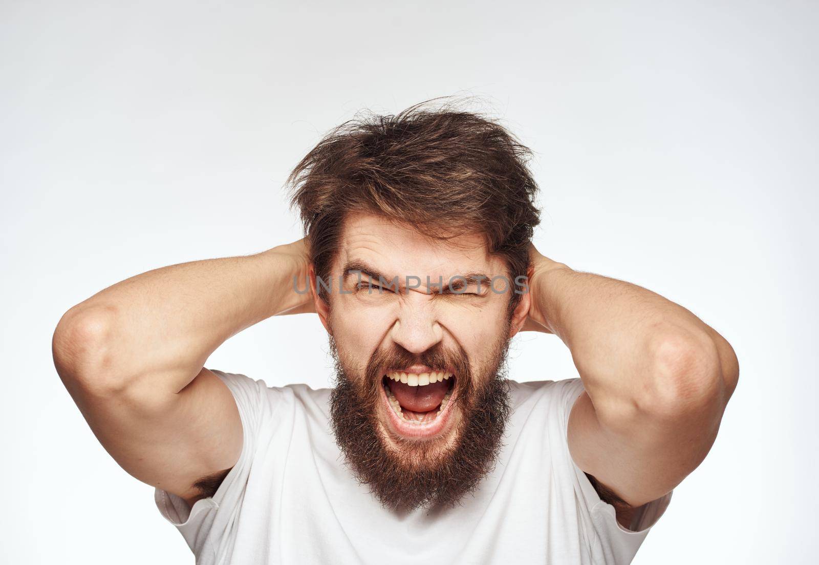 energetic man in white t-shirt gestures with his hands emotions open mouth. High quality photo