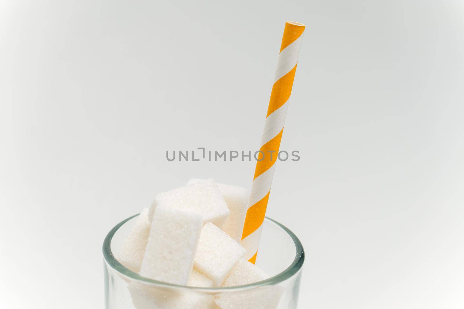 sugar cubes in a glass with a straw calories cocktail glucose sweets. High quality photo