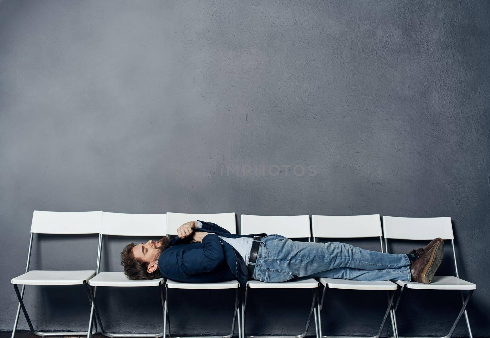 A man lies on chairs waiting for an interview job manager professional. High quality photo